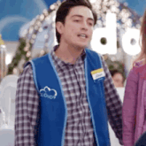 a man wearing a blue vest that says lloyd 's on it