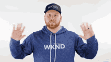 a man wearing a blue wknd hoodie and hat