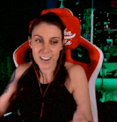 a woman is giving a thumbs up while sitting in a red chair with a coca cola pillow on her head