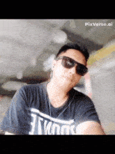 a man wearing sunglasses and a black t-shirt with the word twins on it