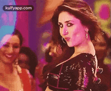 a woman with a nose ring is dancing in front of a crowd .