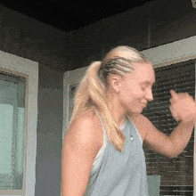 a woman wearing a grey tank top is dancing