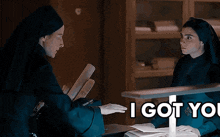 two nuns are shaking hands in a dark room with the words i got you above them