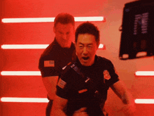 two police officers are standing next to each other in front of red lights
