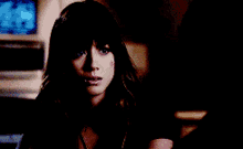a close up of a woman 's face in a dark room .