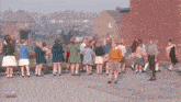 a crowd of people are gathered in front of a fruit stand that has a sign that says ' apples ' on it