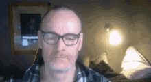a man wearing glasses is looking at the camera