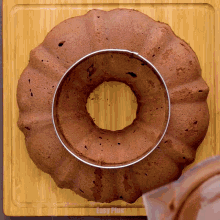 a chocolate cake with a hole in the middle is on a cutting board that says easy plus