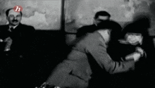 a black and white photo of a group of people with the letter h on the bottom right