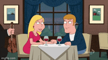 a man is playing a violin while a woman sits at a table with glasses of wine