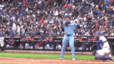 a baseball player in a blue jays uniform swings his bat at a pitch