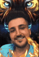 a man is smiling in front of a painting of a tiger 's face