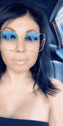 a woman wearing sunglasses and earrings is sitting in a car