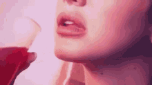 a close up of a woman 's mouth drinking from a glass of wine .