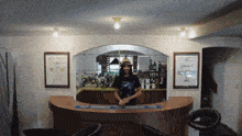 a man in a hat stands behind a bar with a guinness bar mat on it