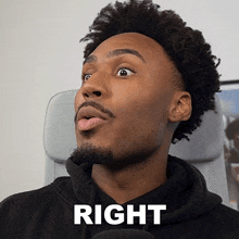 a man with a beard and a black hoodie has the word right written on his face