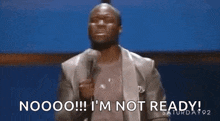 a man in a suit is holding a microphone and saying `` nooo ! i 'm not ready ! ``