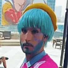 a man with blue hair and a beard is wearing a yellow hat