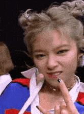 a close up of a woman giving the peace sign with her fingers .