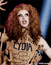 a drag queen wearing a shirt that says lydia