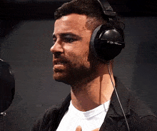 a man wearing a pair of headphones with the letters tp on the side