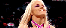 a close up of a woman wearing a pink and white outfit and smiling .