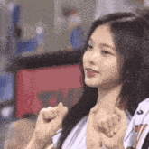 a close up of a girl making a heart shape with her fingers .