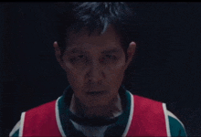 a close up of a man 's face wearing a red and green shirt