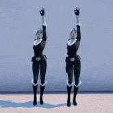 a woman in a black and white superhero costume stands with her arms up