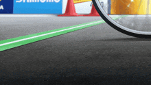 a bicycle is going down a road with a sign that says shimano in the background