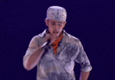 a man with a bandana on his head is standing in front of a microphone and says timber timber timberlake