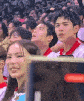 a group of people are sitting in a stadium watching a game ..