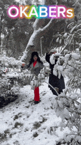 a couple standing in the snow with the word okabers on the bottom