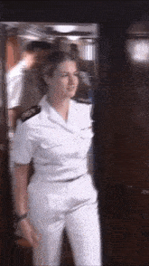 a woman in a military uniform is standing in a room