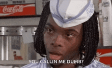 a man wearing a hat and braids is talking to someone in a diner .