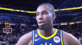 a basketball player wearing a blue and yellow jersey with the number 6 on it is standing on a court .