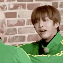 a man in a green jacket is hugging another man .