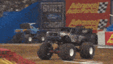 a monster truck is driving past a ford built tough sign
