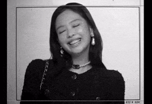 a black and white photo of a woman wearing a necklace and earrings