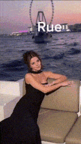 a woman in a black dress is leaning on a couch in front of a ferris wheel and the word rueil