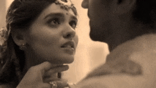 a man and a woman are looking into each other 's eyes and touching each other 's faces .