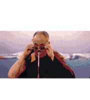 a man is wearing glasses and holding a straw in his nose