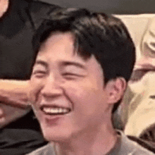 a close up of a man 's face with his eyes closed and a smile on his face .