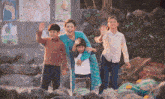 a group of people are standing in front of a wall with a poster that says ' a ' on it