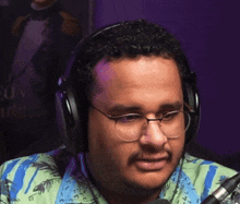 a man wearing headphones and glasses looks at the camera
