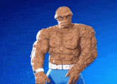 a statue of the thing from the fantastic four standing in front of a blue background
