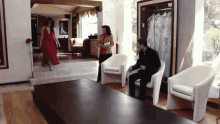 a woman in a red dress is walking towards a man in a suit
