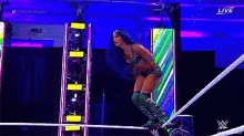 a woman in a wrestling ring is jumping over a rope .