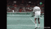 a man stands on a tennis court in front of a compaq advertisement