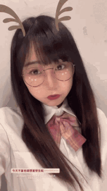 a girl wearing glasses and antlers takes a picture of herself